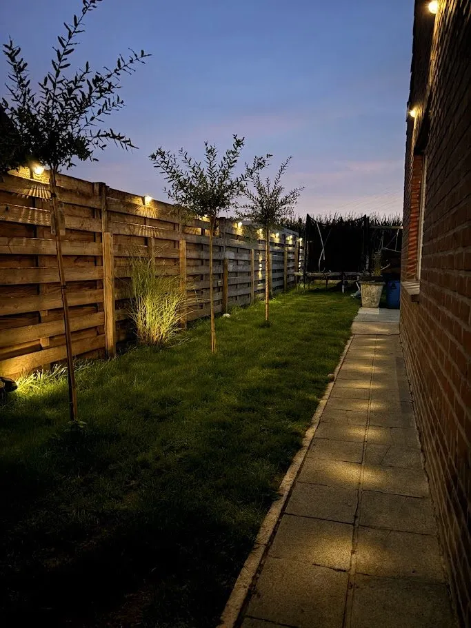 Aangelegde tuin met terras, borders en tuinverlichting door L&R Projects